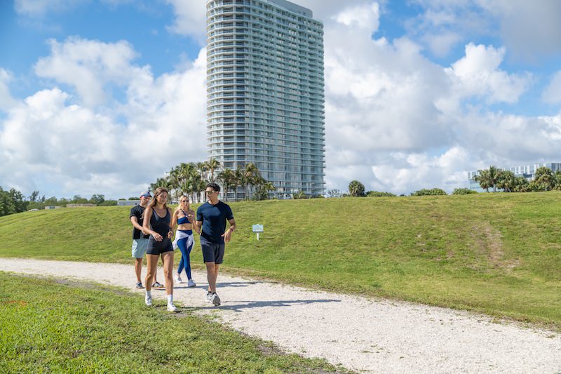 people walking on a trail with a building behind them