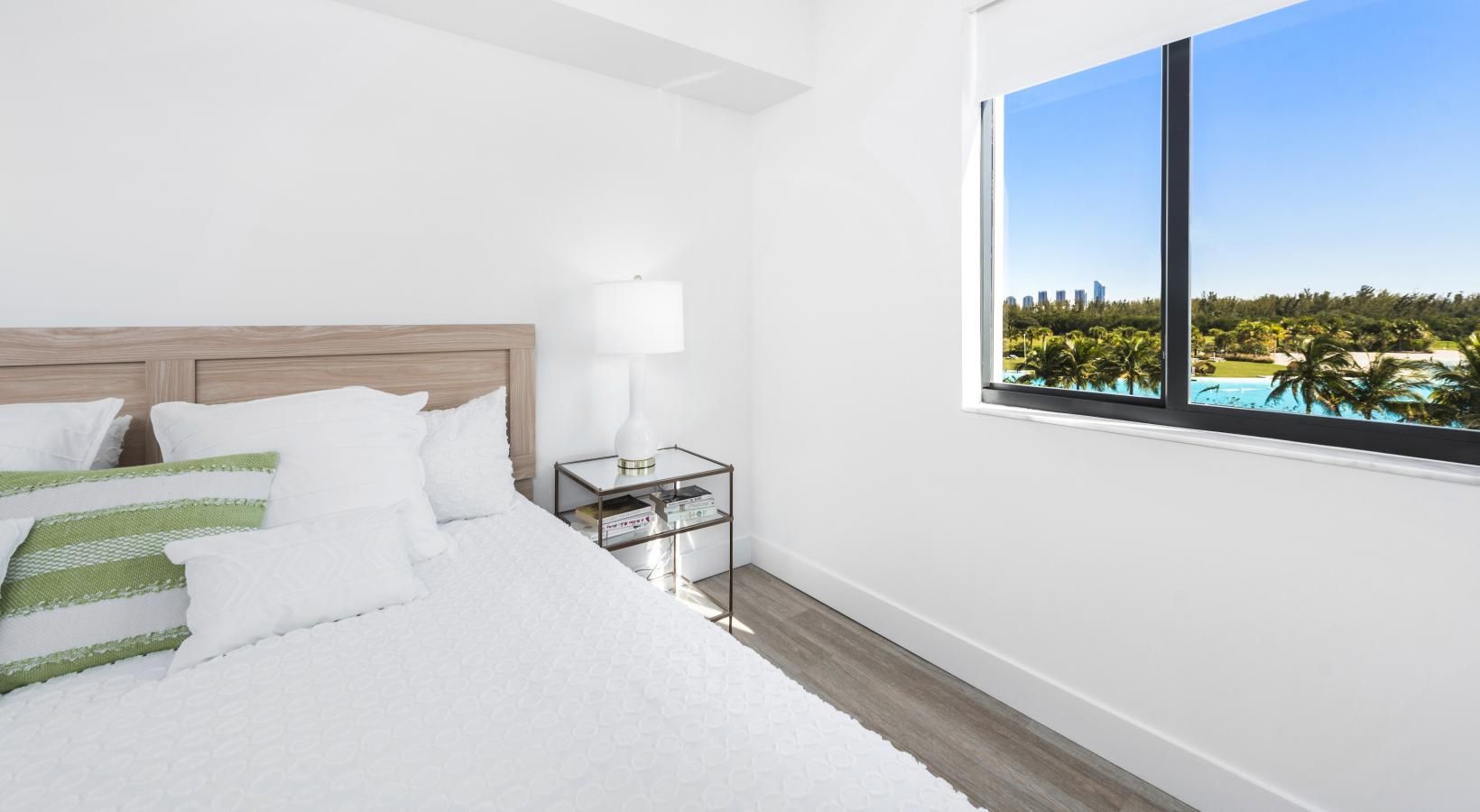 Wake up to natural light and tranquil views from a spacious, thoughtfully designed bedroom. a bedroom with a bed and a nightstand
