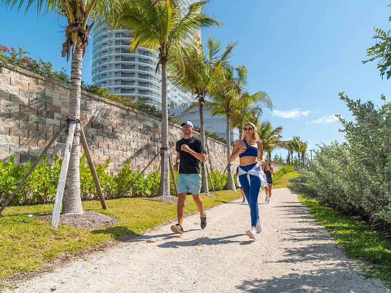 Get your workout on people running along a path with palm trees