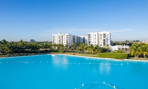 a body of water in front of trees and buildings