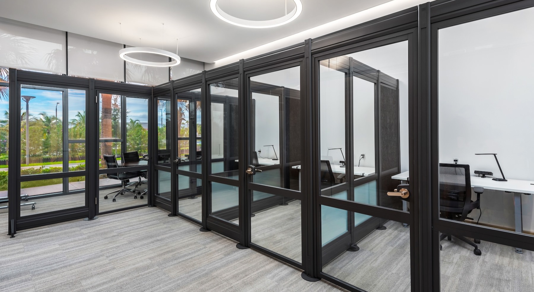 multiple private rooms with desks, chairs and computers