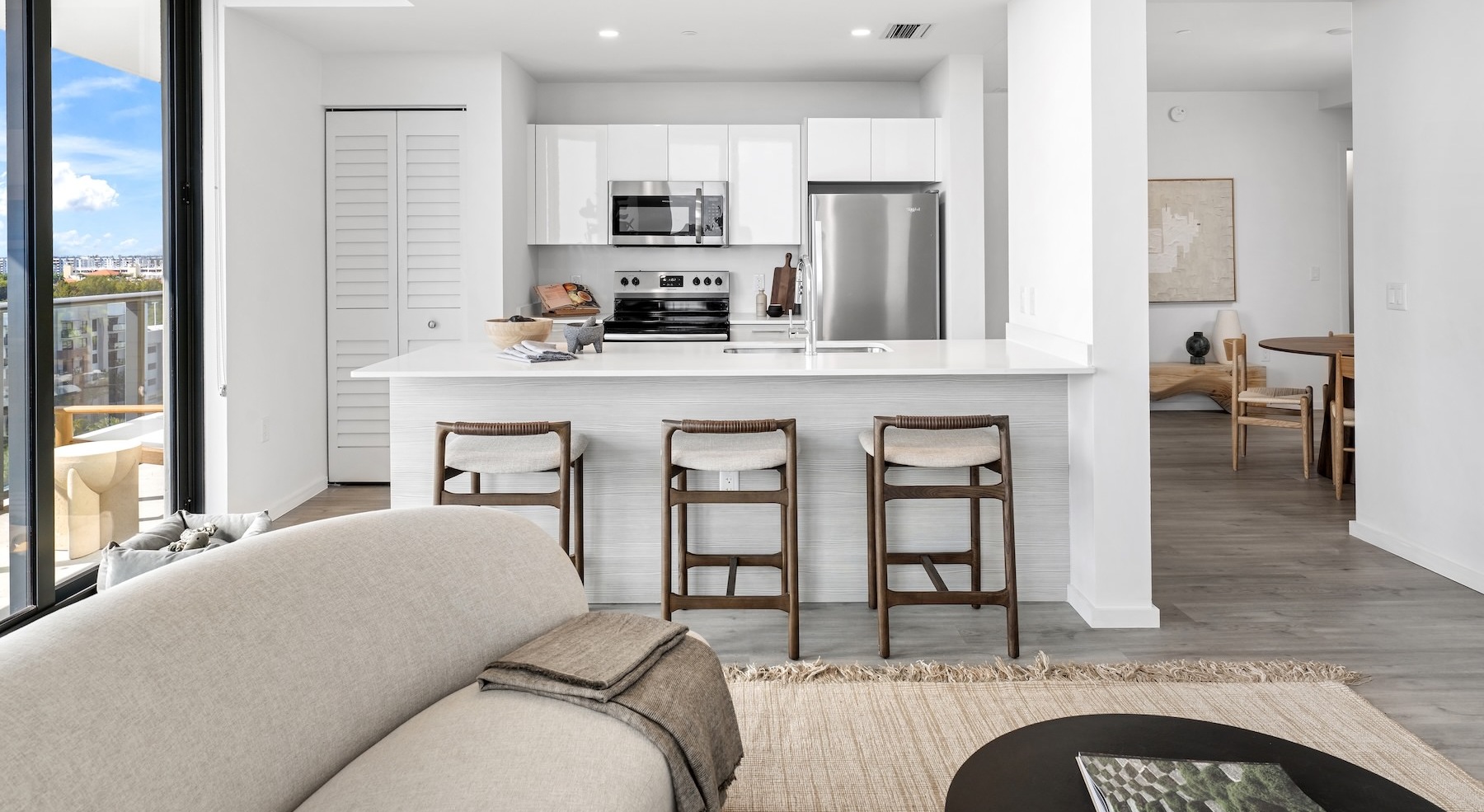 a kitchen and a living room with a couch and chairs