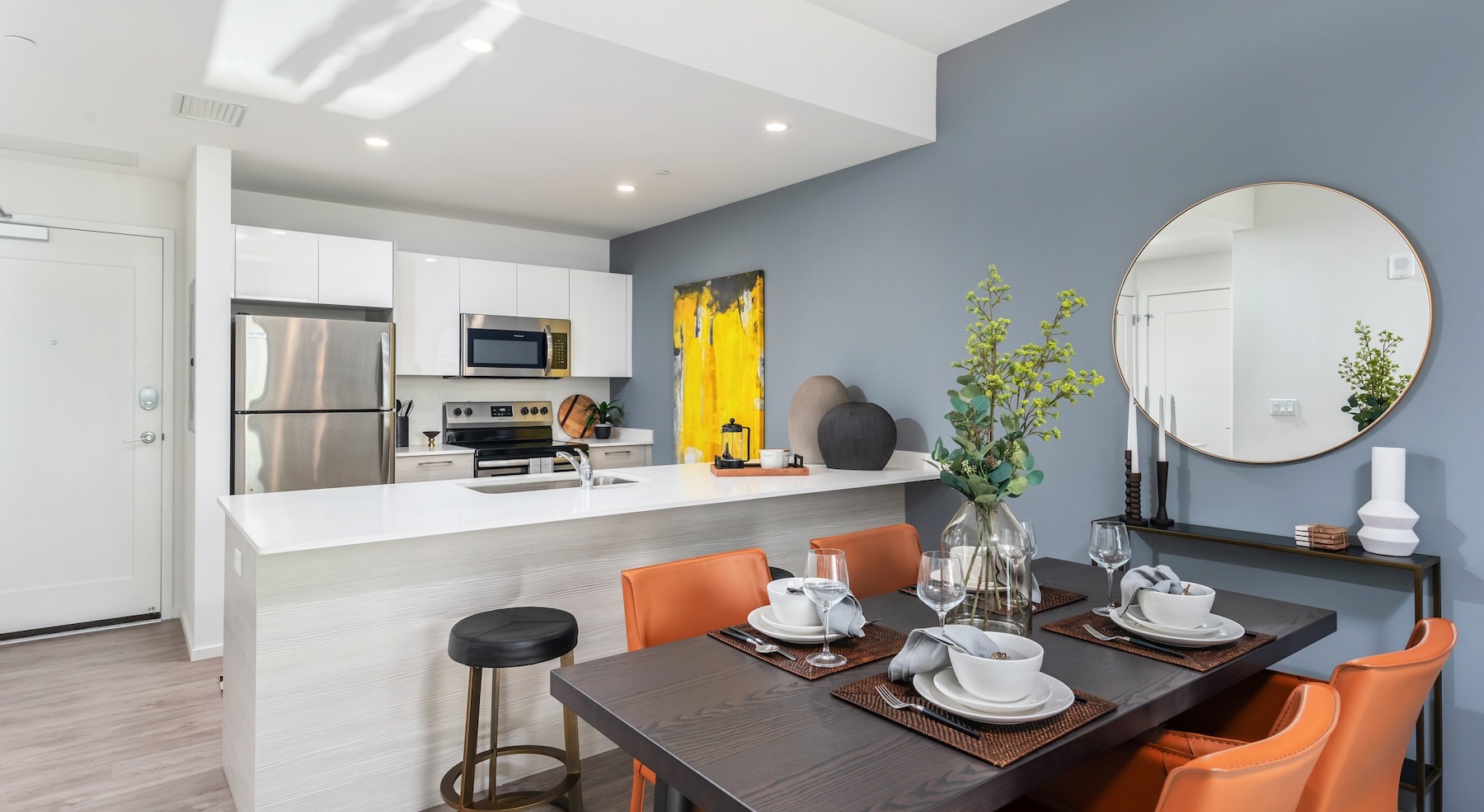 a kitchen with white cabinets and a table with chairs