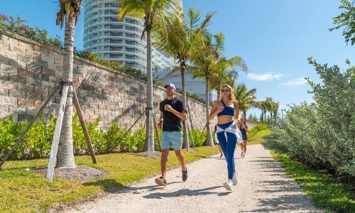people running along a path with palm trees
