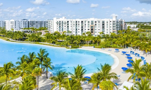 a large building with a pool and palm trees