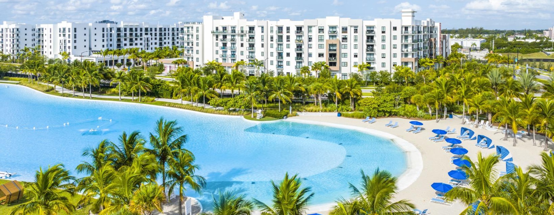 a large building with a pool and palm trees